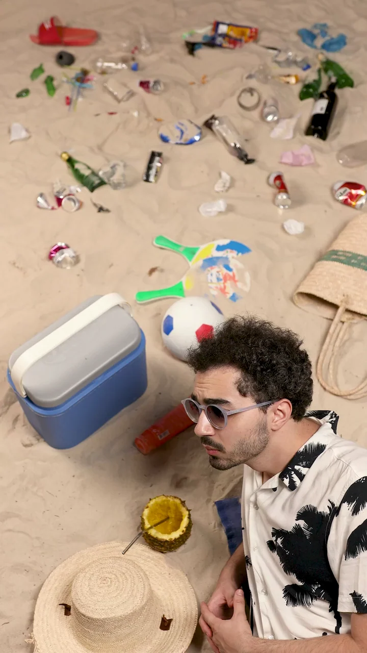 Climate and Pollution: Baha Lajmi on a beach surrounded by scattered litter